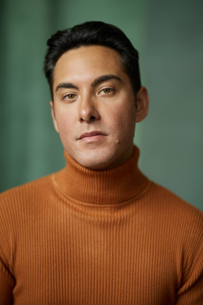 Montreal-actors-headshot-orange-turtleneck-sweater-olive-green-curtain-by-nadia-zheng